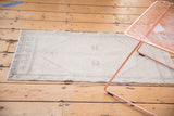 Distressed vintage Oushak rug displaying its muted hexagonal medallion with soft ivory and silver tones.