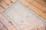 Faded, distressed geometric motifs of a vintage Oushak rug in antique ivory and silver.