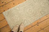 Distressed Oushak rug mat with muted ivory, green, and blue rams horn motifs.