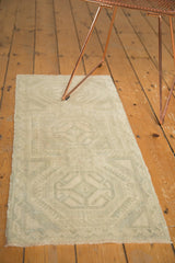 Distressed ivory and sea foam green zig-zag vine border on a vintage Oushak rug corner.