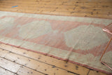Vintage Distressed Oushak runner edge, highlighting faded cinnabar and ivory pattern with abrash.