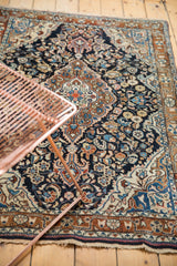 Vintage Sarouk rug corner with meandering vine border and floral field pattern.