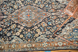 Vintage Sarouk rug's hand knotted floral field and Jozan border with navy, bronze, and blush tones.