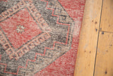Cherry red, charcoal, and beige hook and latch geometric motif on a distressed Oushak runner.