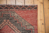 Distressed vintage Oushak rug edge, geometric hook and latch in cherry red, charcoal, beige.