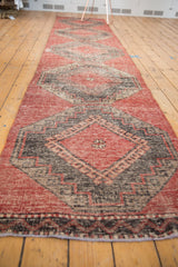 Distressed vintage Oushak runner detail: geometric charcoal and cherry red end border.