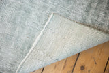 Textured low shorn pile and woven foundation of a distressed pale aqua Oushak rug runner.