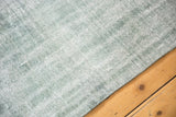 Overcast pale sea foam green and aqua distressed low pile with even wear.
