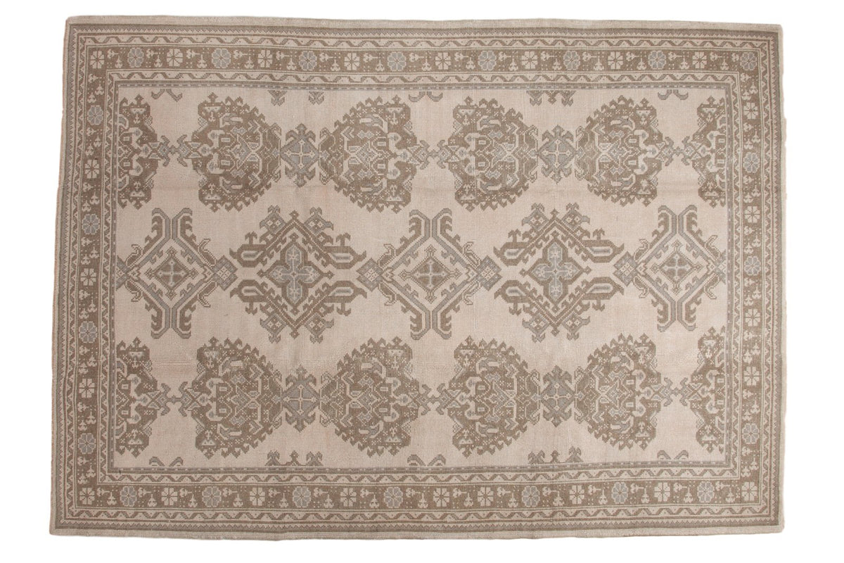 Distressed Oushak carpet, allover densely ornamented floral pattern in sand beige, coffee brown, slate gray.