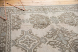 Low pile texture and muted floral patterns on a distressed vintage Oushak carpet.