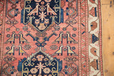 Geometric lovebird motifs in dusty rose and indigo on an antique Persian Malayer runner.