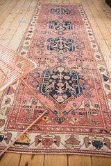 Antique Malayer rug corner, revealing lovebird motifs in dusty rose field and layered ivory border.