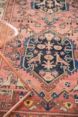 Detail of antique Malayer runner with lovebird motif, indigo medallion, and time-softened dusty rose field.