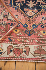 Antique Malayer runner's hand-knotted ivory geometric border with faded tones and visible wear.