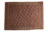 Antique Turkmen hand-knotted carpet featuring allover floral guls in chestnut, navy, and ivory.