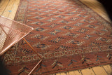 Antique Turkmen carpet's rhythmic guls and intricate borders in chestnut brown, navy, sky blue.