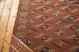 Antique Turkmen carpet's repeating geometric guls with complex fills in chestnut, navy, and beige.