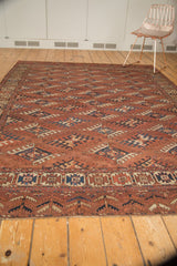 Antique Turkmen carpet's geometric gul pattern and lower border in chestnut, navy, beige.