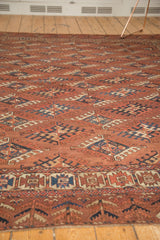 Antique Turkmen rug showing geometric guls and main border in chestnut, navy, beige hues.