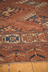 Low pile antique Turkmen carpet, showing geometric guls, knot heads, and block-patterned border.