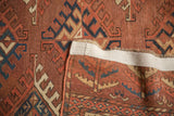 Antique Turkmen carpet detail: low pile, chestnut, navy, beige guls, and secured edge.