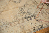 Distressed Sivas carpet, pale melon and charcoal geometric pattern with visible foundation.