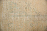Distressed Sivas carpet texture, with pale melon, ivory, and seafoam green geometric patterns.