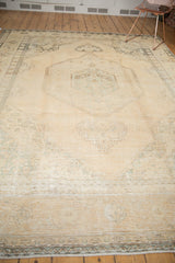 Distressed Sivas carpet with faded geometric outlines on pale melon, revealing textured wear.