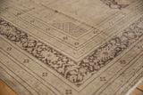 Distressed Persian Khorassan carpet corner with intricate charcoal border and ivory foundation wear.