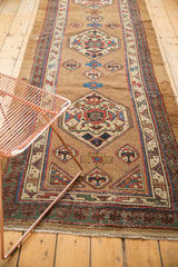 Antique Serab runner's geometric medallion detail, in bronze, blue, red, and ivory with visible knot wear.