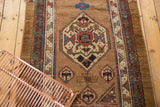 Antique Serab rug runner's central medallion featuring ivory, red, and blue geometric motifs.