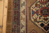Detail of antique Serab runner: bronze border, camel and blue geometric medallion, with wear and etching.