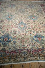 Distressed Kerman carpet allover lattice pattern in ivory, sky blue, fuchsia, and rose.