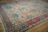 Distressed vintage Kerman carpet section with vibrant fuchsia border and sky blue floral details.