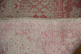 Distressed Oushak rug showing worn silver, raspberry pile and hand-knotted foundation.