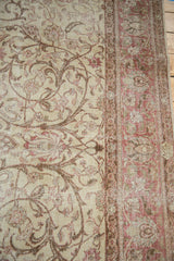 Distressed Sivas rug's ivory field, blush floral vinery, and muted border detail.
