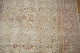 Distressed Sivas carpet texture, showing allover scrolling vinery in softened ivory and blush.