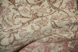 Textural detail of a distressed Sivas carpet, highlighting faded blush and bronze scrolling vinery.