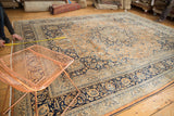 Corner of vintage Meshed carpet featuring navy border, pale rust field, intricate palmettes, and vinery.