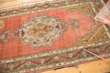 Vintage Anatolian runner with dusty rose field, intricate meandering vine border, and scalloped motif.