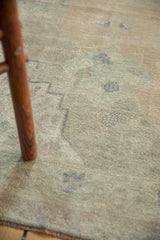 Distressed vintage Oushak rug detail, showing faded olive green and dusty beige low pile.