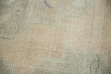 Distressed low pile texture of vintage Oushak rug in faded antique ivory and dusty beige.