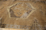 Worn texture and serrated geometric contour of a vintage distressed Oushak carpet.
