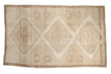 Distressed vintage Turkish Oushak carpet with three oversized geometric medallions in sand and ivory.