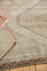 Distressed vintage Oushak carpet with worn low pile, primitive geometric motifs, and abrashes.