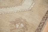 Distressed beige Oushak rug close-up: low pile, tone-on-tone colors, and subtle abrashes.