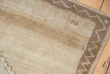 Distressed vintage Oushak carpet pile with visible abrash and geometric brown border.