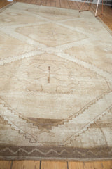 Low pile texture and abrashes striating across a distressed vintage Oushak rug.