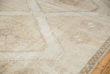 Distressed vintage Oushak carpet showing tone-on-tone geometric motifs and original cord selvage.