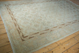 Distressed Turkish Sparta carpet corner with pale coffee bronze lattice border and faded ivory floral motifs.